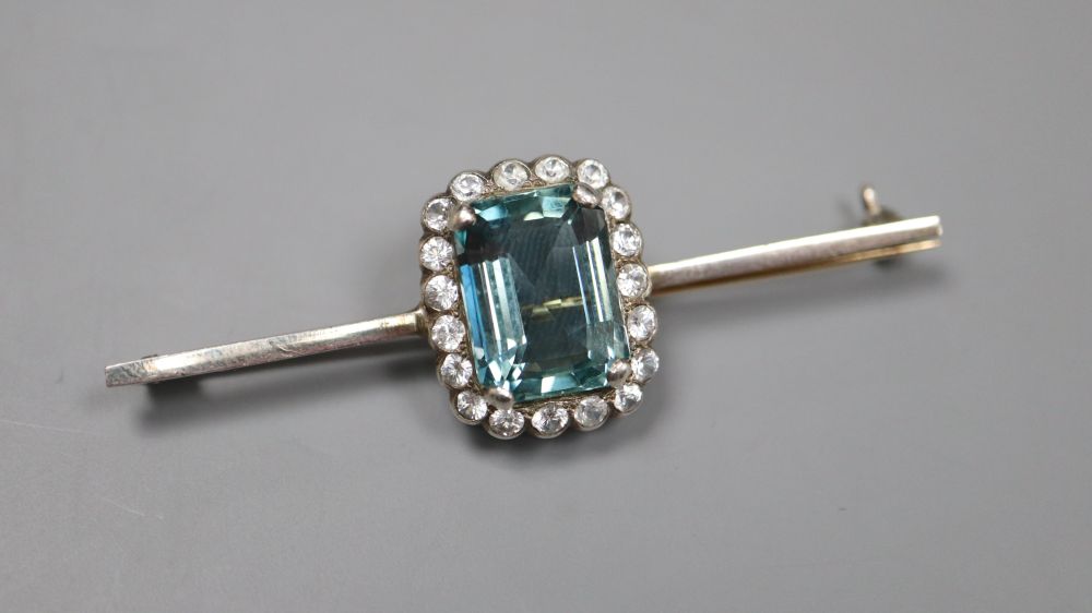 A white and yellow metal, emerald cut aquamarine and white topaz set bar brooch, 6cm, gross 7.2 grams.